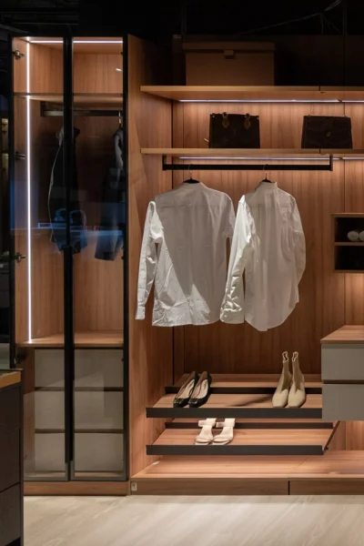 Glass-front wardrobe with integrated LED lighting and hanging clothing storage