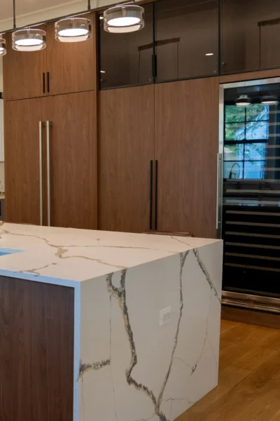 Modern kitchen island with marble waterfall countertop and wood cabinetry