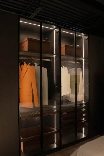 Custom wardrobe with open doors revealing illuminated storage and hanging garments