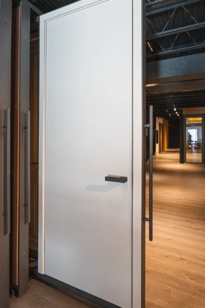 Modern white interior door with minimalist handle displayed in showroom