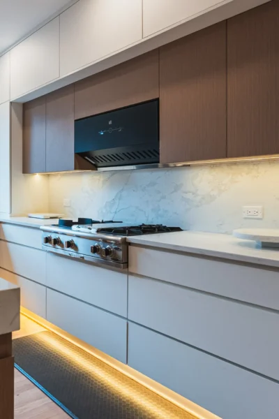 Modern kitchen with marble backsplash, wood cabinets, and built-in gas range