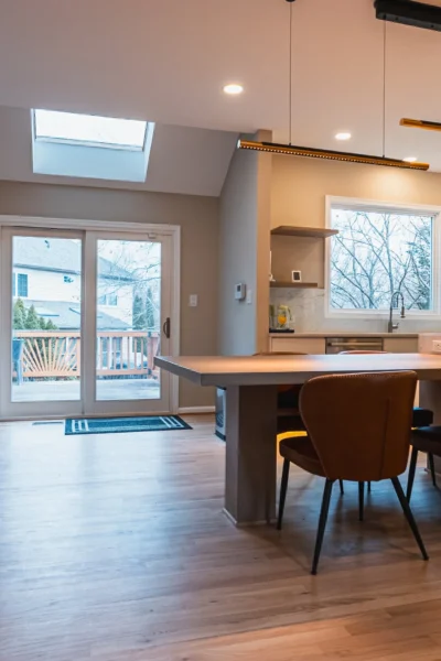 Contemporary kitchen and dining area with large island, skylight, and sliding glass doors