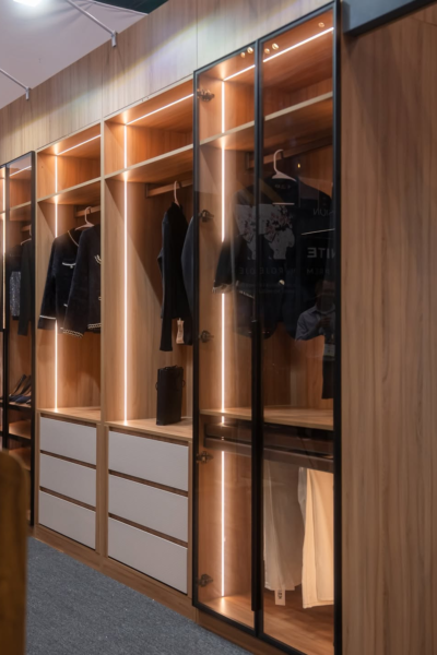 Modern custom closet showroom display with illuminated wooden cabinetry